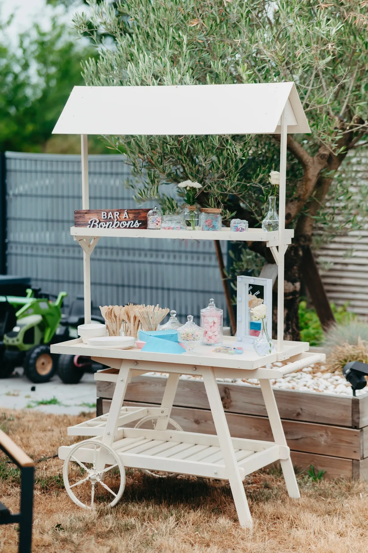 Bar à bonbons en bois blanc dressé dans un jardin