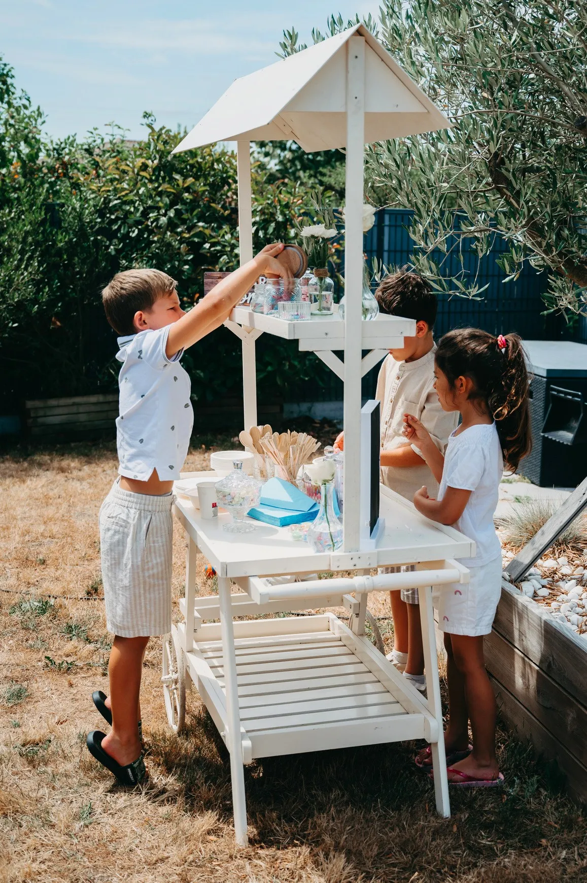 Des enfants se servent au bar à bonbons dans un jardin