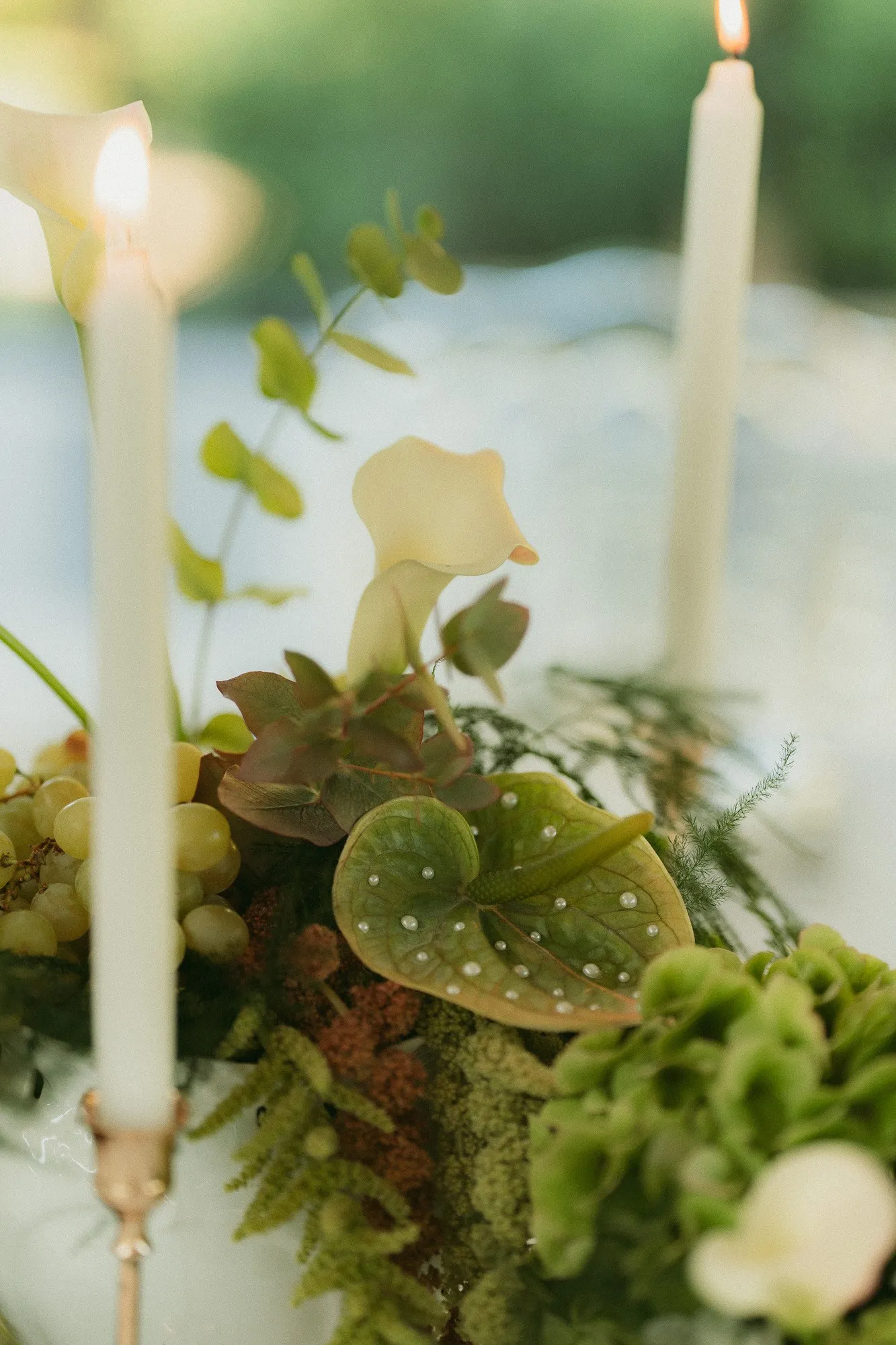 Bougie, arum et anthurium au cœur d'un centre de table végétal