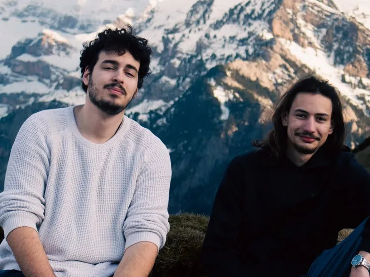 Les deux vidéastes de Laelaps, assis devant un massif enneigé