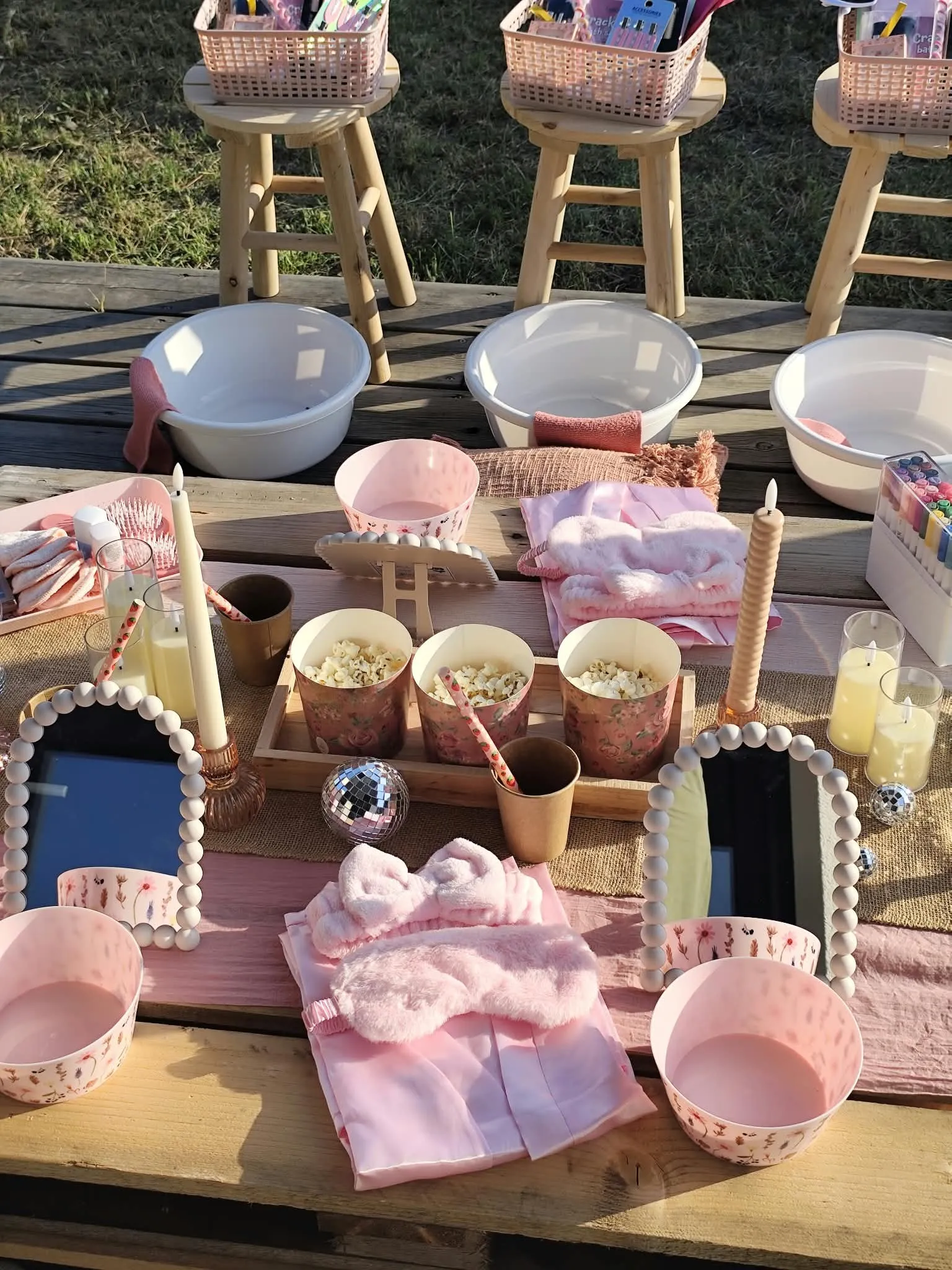 Table de spa dressée en extérieur : bols, peignoirs et miroirs pour chaque invitée