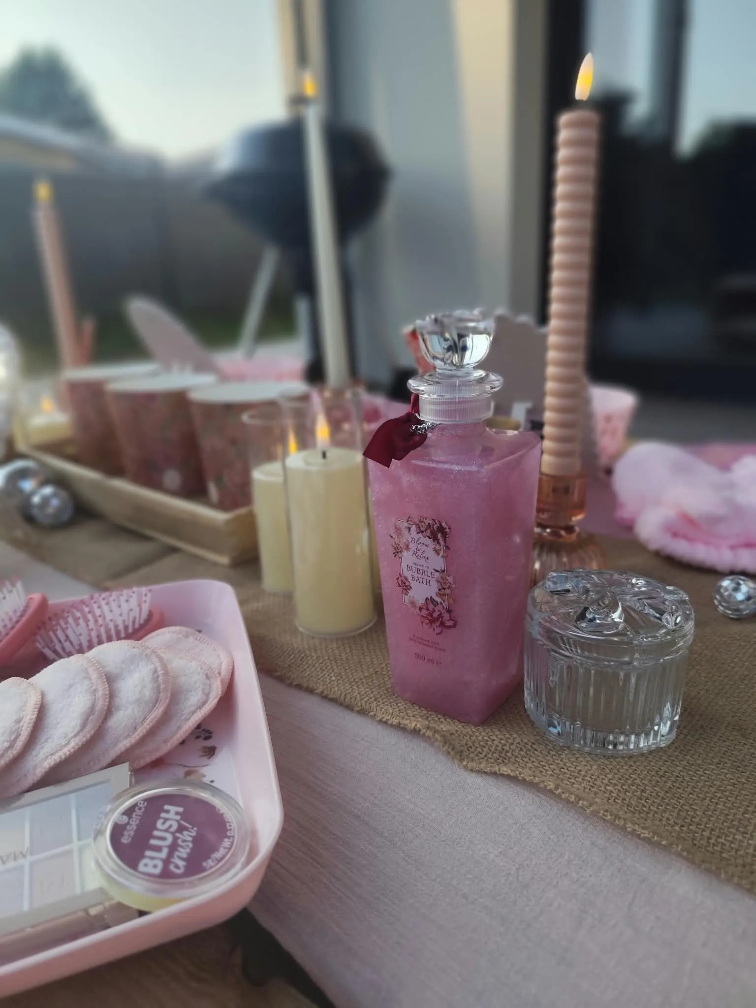Bougies, carafe rose et lunettes cœur sur la table du spa
